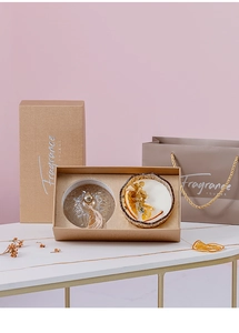 Detailed gift set featuring amber glass scented candles with a retro embossed lid and gift bag