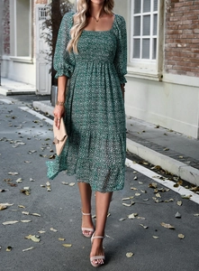 Green floral midi dress with square neckline and puff sleeves on street background