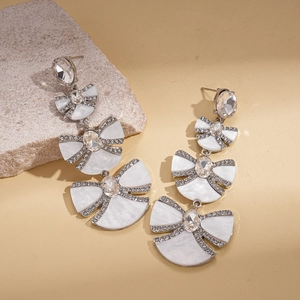 Detail of silver long earrings featuring resin bow design and sparkling crystal rhinestones