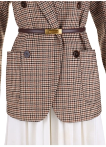 Detail view of brown genuine leather slim belt with gold buckle on a tweed blazer jacket