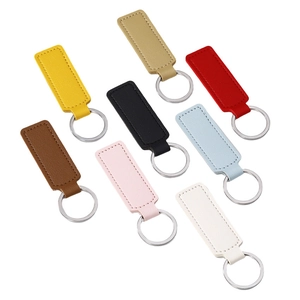 Eight colors of PU leather keychains with stitching and silver metal rings on white background