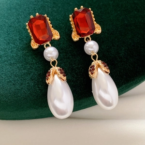 Detail of vintage square red gemstone and large pearl drop earrings with gold accents