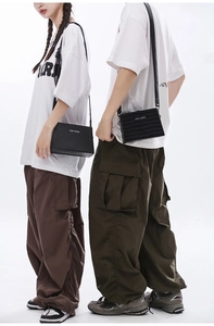 Street style shot of two models wearing black box-shaped crossbody bags and oversized tees