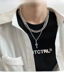 Close-up of double layer silver stainless steel cross pendant necklace on a male model