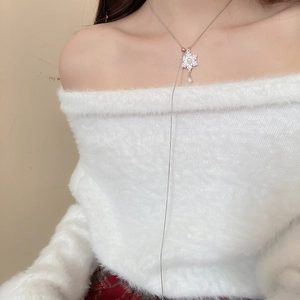 Silver snowflake necklace with pink bow and pearl accent worn by a model in close-up