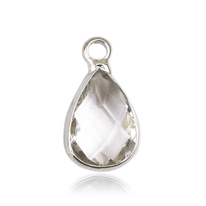 Macro shot of a teardrop-shaped glass birthstone pendant in a silver metal frame