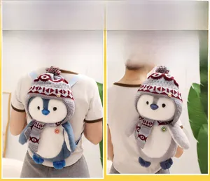Detail of penguin plush backpack showing knitted hat, scarf and versatile carrying straps