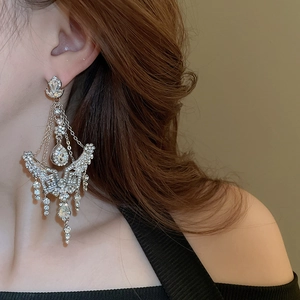 Close-up of sparkling flower waterdrop tassel earrings worn on a model's ear