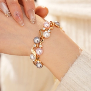 Mannequin portant un bracelet doré avec perles roses, grises, blanches et cristaux brillants