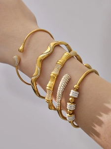 Gros plan d'un ensemble de 5 bracelets en acier PVD doré avec zircons 5A brillants