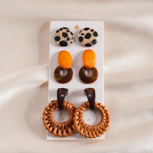 Three pairs of Bohemian earrings featuring leopard print, wood, and woven rattan details