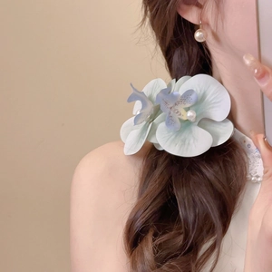 Blue and white gradient fabric orchid hair clip with pearls on dark wavy hair