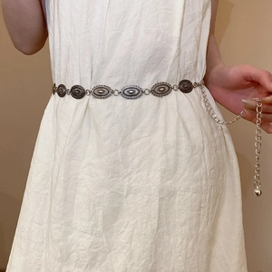Detail of vintage silver metal chain belt with oval carved plates on a white dress