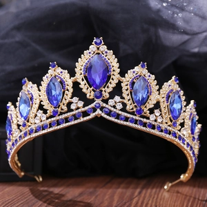 Detail of baroque gold crown with large blue oval crystals and white rhinestones
