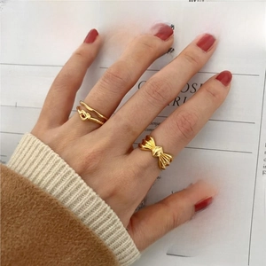 Elegant 925 sterling silver twisted knot and bow rings set on hand with red nails