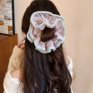 Detailed knit texture of pink and green double-layer flower hair scrunchie on brown wavy hair