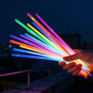 Vibrant multicolor glow sticks for parties held in hand against dark night background