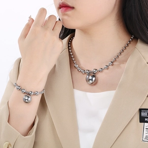 Detailed view of silver titanium steel bead necklace and bracelet set on a female model