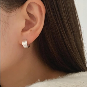 Chic 925 sterling silver hoop earrings with vertical texture shown on ear