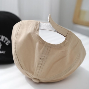 Détail de la fermeture velcro réglable sur une casquette en coton beige pour enfant