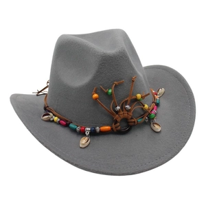 Detail of grey felt cowboy hat with bohemian colorful beads and shell pendant decorations