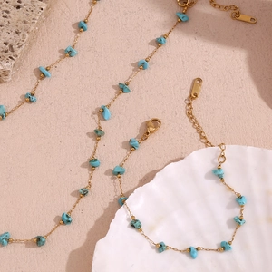Detail of 18K gold-plated necklace with turquoise gravel and lobster clasp on seashell