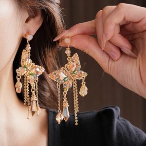 Détails des boucles d'oreilles papillon en cristal avec pompons et perles dorées