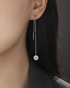Macro view of long 925 sterling silver chain earrings with brilliant round moissanite drop