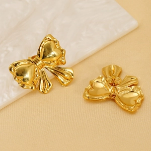 Elegant gold bow earrings with heart details and polished finish in diagonal view