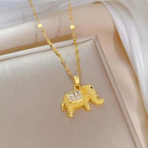 Macro shot of gold elephant pendant with square-cut sparkling zircon on titanium steel chain