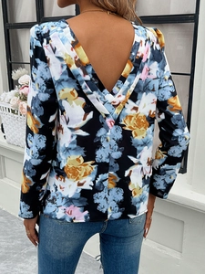 Detail of floral long sleeve top featuring a unique V-back cutout design and print