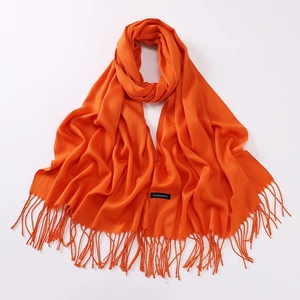 Detailed macro view of the premium orange cashmere scarf featuring elegant fringe tassels