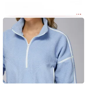 Detail of light blue fleece sweatshirt with white piping and stand-up collar zip