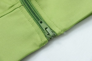 Detailed close-up of grass green jacket zipper and high-quality knit texture of yoga set