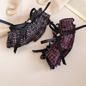 Detail of vintage plaid fabric bow hair claws with elegant lace edges and ribbon accents