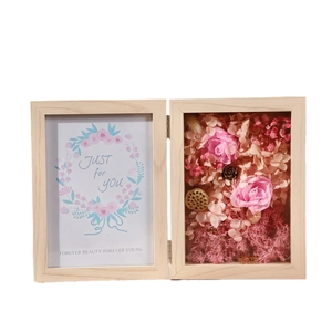 Deep wood shadow box with pink preserved roses and decorative floral arrangement