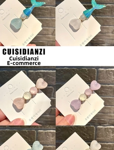 Detailed view of macaron heart and fishtail hair clips with glitter finish on display card