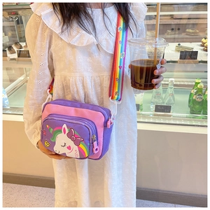 Girl wearing cartoon unicorn crossbody bag with a rainbow strap in a bright bakery shop