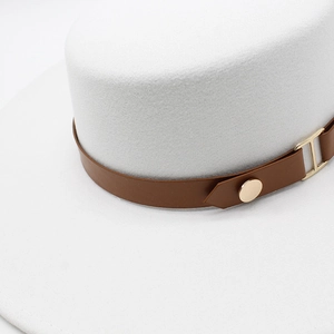 Detail of white wool felt boater hat featuring a brown leather belt and gold metal buckle