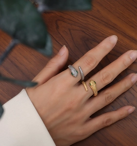 Detail of 18k gold plated snake ring with green zircon eyes and scale texture