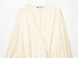 Vue détaillée du col en satin beige et du décolleté en V avec texture douce et soyeuse