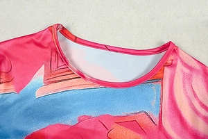 Close-up of pink crew neck collar with fine stitching and vibrant artistic print detail