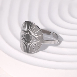 Macro shot of silver evil eye totem ring on minimalist white plaster base