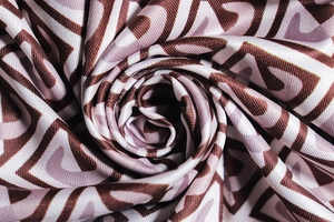 Macro shot of silk-like geometric fabric in brown and pink with elegant drape and texture