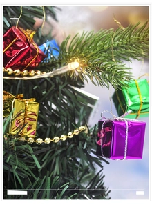 Gros plan de boîtes cadeaux colorées en mousse sur un sapin de Noël avec lumières LED