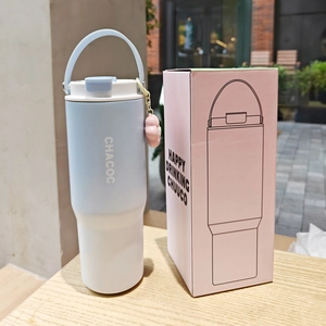 Detail view of light blue and white insulated coffee mug with handle and gift box packing