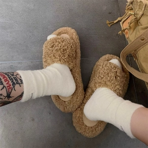 Close-up of thick brown thermal plush socks with NEWCOLOR label on a model's feet