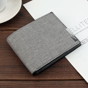 Close-up of grey fabric textured men's wallet with metal accent on a wooden desk
