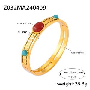 Detail of 1cm wide gold titanium steel bangle with red and lapis natural stone inlays