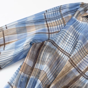 Detail of blue and brown plaid fabric with gold metallic thread and sheer texture